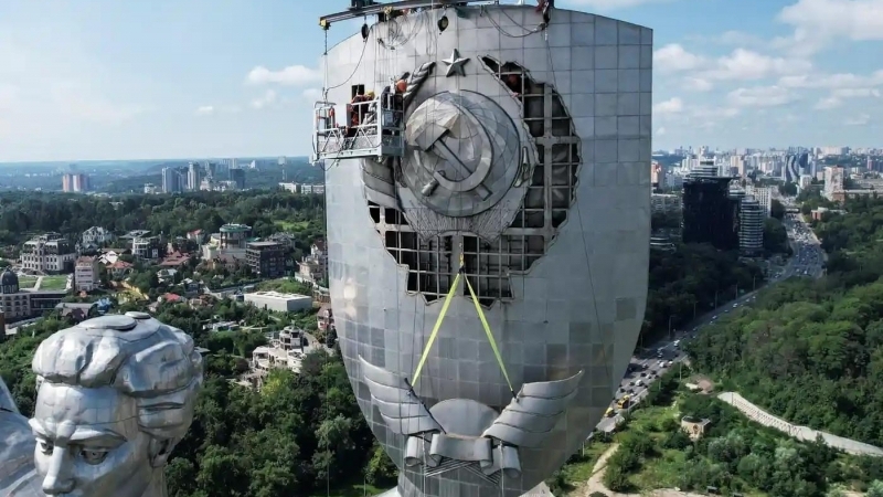 Fotografia dimineții - Mai mulți muncitori înlătură seceră și ciocanul de pe monumentul Patriei, aflat în fața muzeului celui de-al Doilea Război Mondial din Kiev